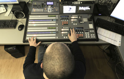 High angle view of tv editor working with video mixer at workspace