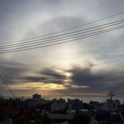 Buildings against cloudy sky at sunset