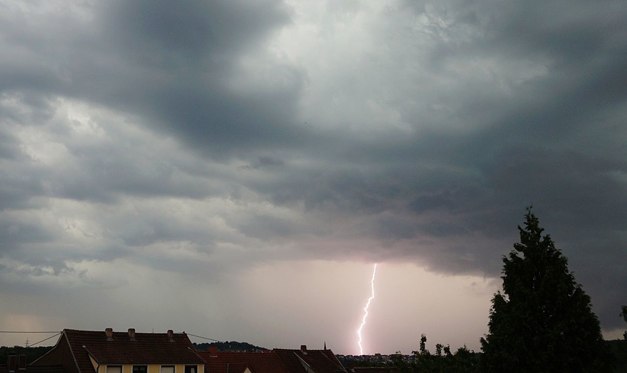 LOW ANGLE VIEW OF LIGHTNING OVER CITY AGAINST SKY