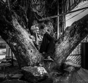 Man sitting on rock in forest