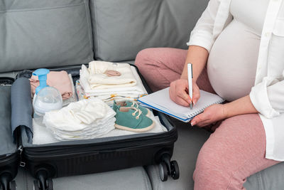 Midsection of woman reading book at home