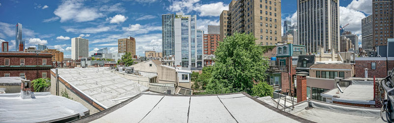 Buildings by swimming pool in city against sky