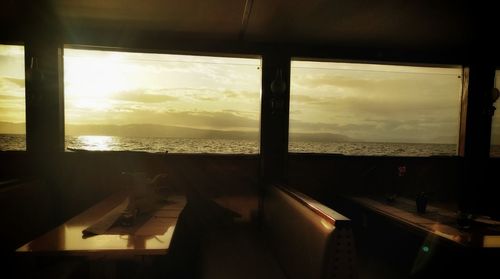 Sea seen through window at sunset