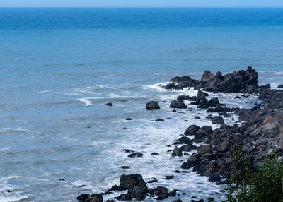 Rocks on sea shore against sky