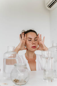 Portrait of smiling female friends in bottles against white background