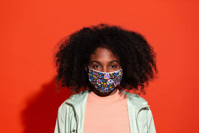 Portrait of beautiful young woman against red background