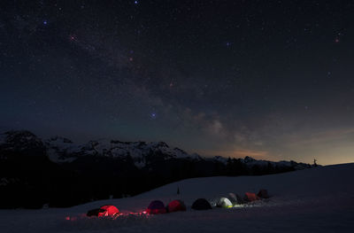 Scenic view of snowcapped mountains against sky at night