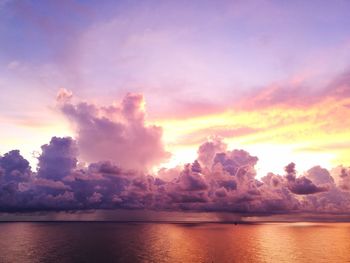 Scenic view of sea against dramatic sky during sunset