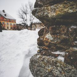 Close-up of snow covered rock by building