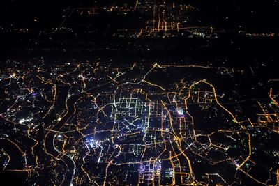 Illuminated cityscape against sky at night