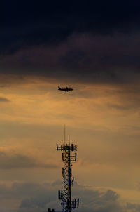 Low angle view of airplane flying against sky during sunset