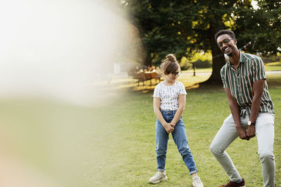 Smiling man and girl in park