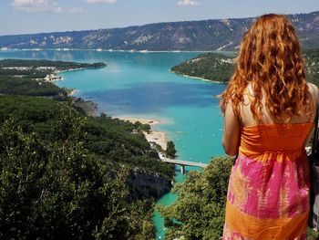 Rear view of woman looking at sea against sky