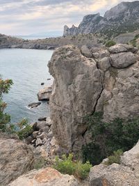 View of rock formation by sea against sky