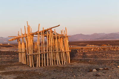 Wooden structure on field against clear sky