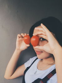 Close-up portrait of woman holding tomatoes