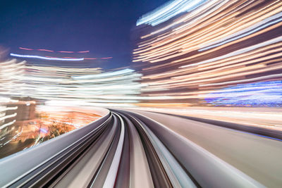 Light trails on railroad tracks in city at night