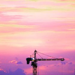 Low angle view of crane against sky during sunset