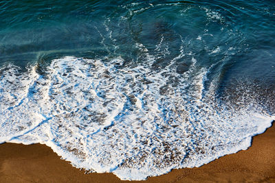 High angle view of waves rushing towards shore