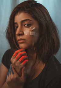 Close-up portrait of beautiful young woman with paint and flower