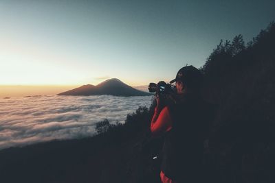 Man photographing cloudscape during sunset
