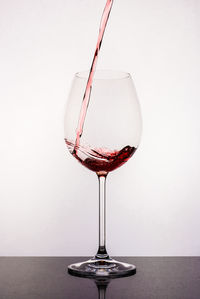 Close-up of wineglass on table against white background