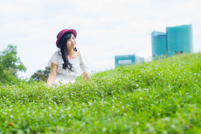 Woman smiling while sitting on field