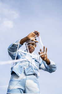 Low angle portrait of man standing against sky