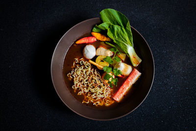 Directly above shot of salad in bowl against black background