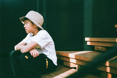 Side view of baby boy sitting on table