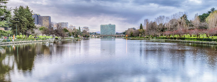 Scenic view of lake by buildings against sky