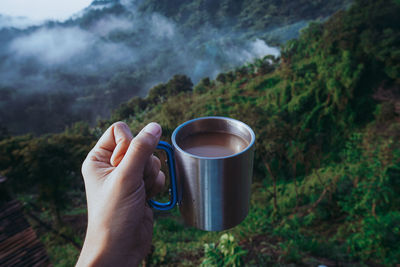 Cropped hand of person holding tea cup