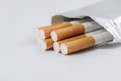 Close-up of cigarette on table against white background