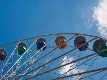 Low angle view of ferris wheel against blue sky