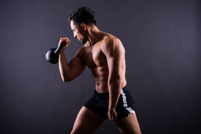 Shirtless man exercising in gym