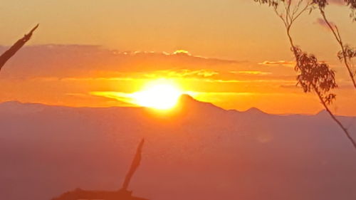 Close-up of orange mountain against sky during sunset