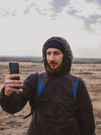 Traveler hiker photographer man  smartphone backpack walking taking picture active lifestyle travel 