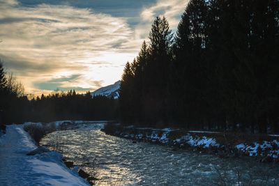 Scenic view of frozen river against sky during winter