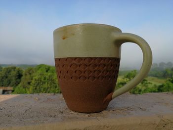 Close-up of coffee cup against sky