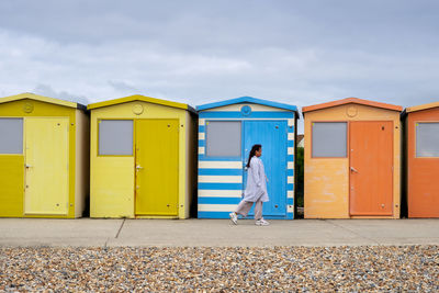 Woman walking along colourful butchhuts