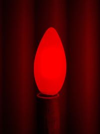 Close-up of illuminated lamp against wall