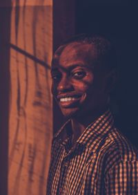 Portrait of young man standing against wall