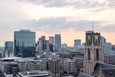 View of cityscape against cloudy sky