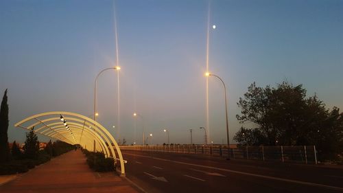 Illuminated road against clear sky