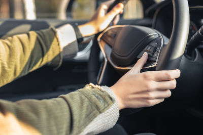 Young woman holding hands on steering wheel. by right hand she changing track. driving car concept.