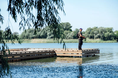 Fisherman with spinning rod on the lake. fisherman with spinning in his hands catching fish at sun