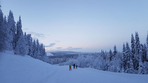 People skiing on snowcapped mountain against sky