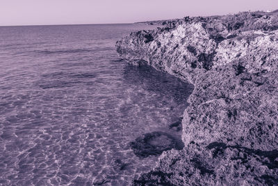 Scenic view of rocks in sea against sky