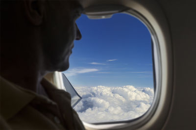 Commercial plane passenger sitting and looking out the window , focus in background