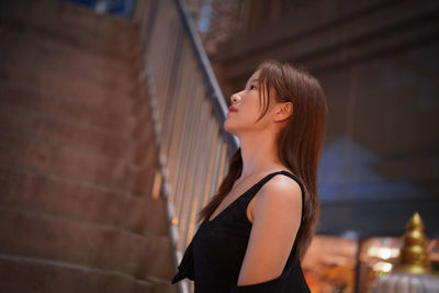 Young woman standing against wall